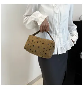 Close-up of brown corduroy pouch with floral print showing texture and handle detail