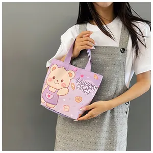 Detailed view of light purple canvas tote bag with lucky baby bear print held by model