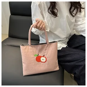 Pink canvas tote bag featuring cute red apple embroidery and sturdy handles