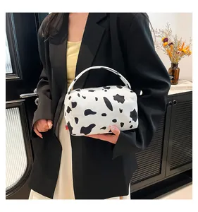 Close-up of a cow pattern corduroy makeup bag with handle and zipper closure details