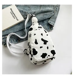 Canvas chest bag with cow print pattern shown with a denim jacket and a book
