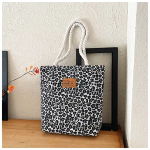 Detail von Canvas-Tragetasche mit Leopardenmuster, Lederpatch und Seilgriffen