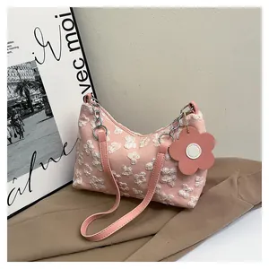 Detail of pink canvas bag featuring 3D floral lace textures and a flower charm