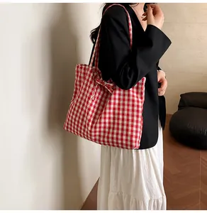 Detail of red and white vichy checkered tote bag with bow decoration on the side