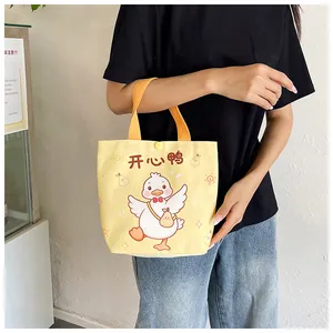 Detail of yellow canvas gift bag with cartoon duck illustration and snap closure handle