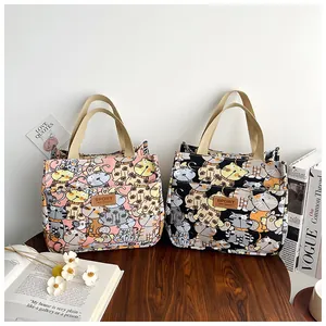 Detail van roze en zwarte canvas lunchtassen met kattenprints en een voorvakje erop