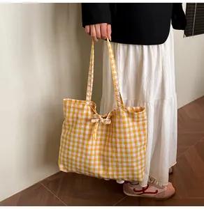 Detailed view of yellow gingham canvas tote bag with a matching decorative bow