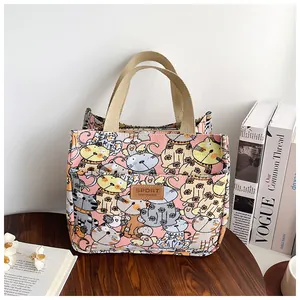 Detail van canvas tas met kattenprint en lederen label op een houten tafel