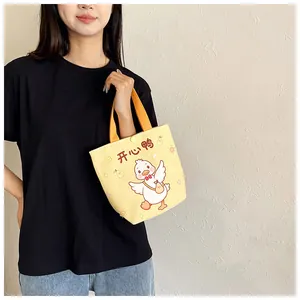 Detailed view of yellow canvas tote bag with cute cartoon duck and snap button closure