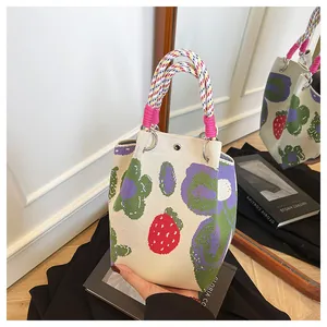 Detail of knitted tote bag with floral patterns and woven handles shown in a mirror
