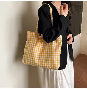 Detail of yellow gingham tote bag featuring a decorative bow tie and soft cotton fabric