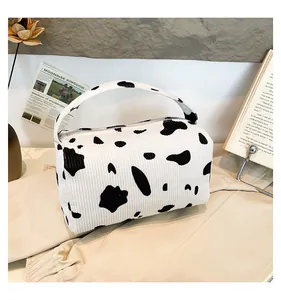 Detailed view of soft corduroy fabric with cow print pattern on a portable storage bag