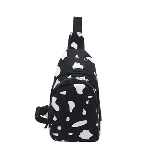 Canvas chest bag with black and white cow print, multi-zipper pockets and adjustable strap