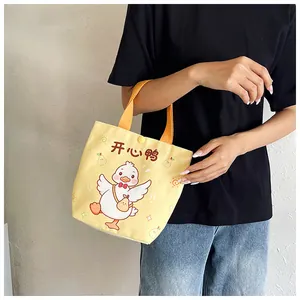 Detail of yellow canvas tote bag with cute cartoon duck and snap button closure