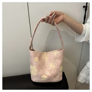 Detailed view of a pink Chinese-style handbag with elegant yellow floral embroidery patterns