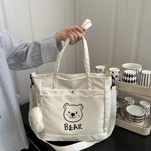 Large beige tote bag with cute bear print and adjustable strap for daily commute