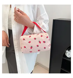 Detailed macro view of pink corduroy storage bag featuring red strawberry patterns