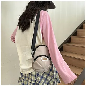 Detail of a beige nylon crossbody bag with geometric texture and adjustable wide black strap