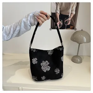 Detail of Chinese style bucket bag with white floral embroidery and black fabric