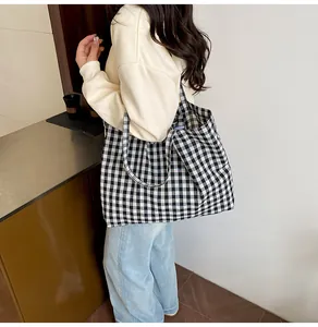 Lifestyle shot of large black and white checkered canvas tote bag with wide straps