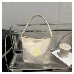 Detailed embroidery of large yellow flowers on a beige Chinese style tote bag