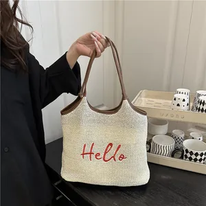 Woven straw tote bag with red Hello embroidery and brown faux leather straps