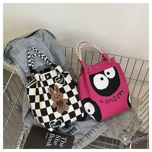 Detail shot of a black and white checkered knit bucket bag and a bright pink cartoon tote bag