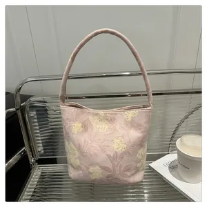 Detailed close-up of pink floral embroidery and premium canvas texture on Chinese bucket bag