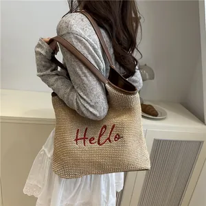 Straw woven shoulder tote bag with red Hello embroidery and brown leather trim detailing