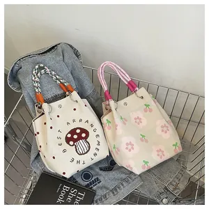 Detailed texture of knitted tote bags with cherry and mushroom patterns in a basket