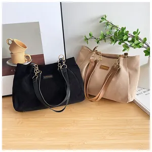Detailed texture of corduroy tote bags in khaki and black with chain straps