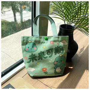 Close-up of green canvas gift bag featuring cute cartoon dinosaurs and a snap button