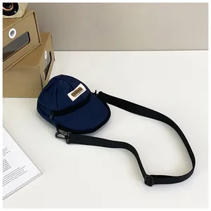 Detailed view of creative baseball cap shaped crossbody bag in navy blue nylon