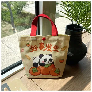 Detail of canvas tote bag with red strap, panda print and Good Things Happen slogan