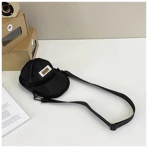 Macro shot of creative black baseball cap shaped nylon crossbody bag with fabric label