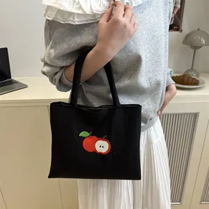 Large black canvas tote bag with red apple embroidery for casual daily use