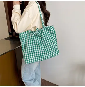 Detailed view of green checkerboard canvas tote bag with decorative bow tie strap