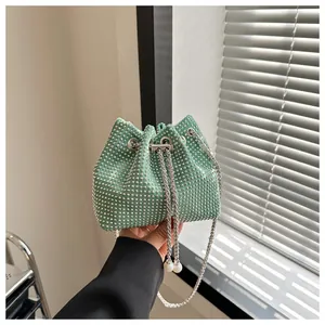Detail van lichtgroene emmertas met strass-steentjes, ketting en parelkoord