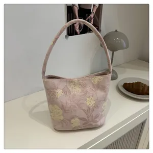 Detail of pink floral embroidery and textured fabric on the large capacity tote bag