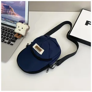 Detail of creative navy canvas baseball cap shaped crossbody bag with adjustable strap