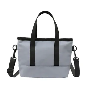 Petit sac fourre-tout bleu en nylon avec anses noires et bandoulière réglable pratique