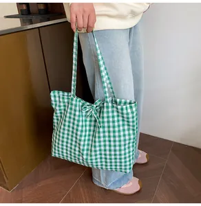 Close-up of green and white gingham tote bag featuring a decorative bow tie detail