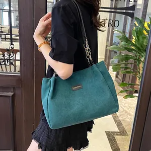 Large dark green corduroy tote bag with fashion tag and gold chain shoulder strap
