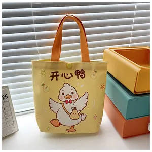 Close-up of yellow canvas bag with cartoon duck print, orange straps and top snap button