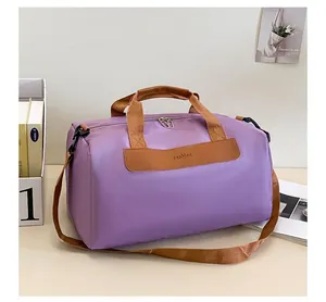 Détail du sac de sport violet avec écusson en cuir Fashion et anses tissées brunes