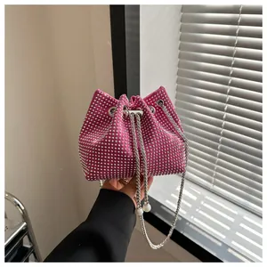 Detail van roze emmertas met strass-steentjes en zilveren ketting met parels