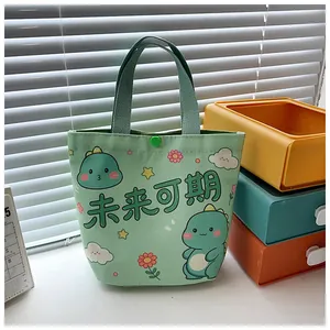 Detail of green canvas tote bag featuring cute cartoon dinosaurs and snap button closure