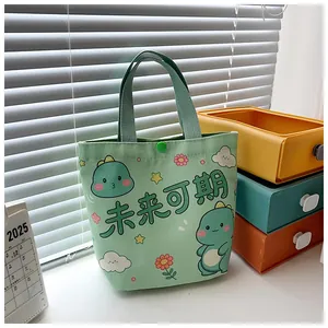 Detail of light green canvas tote bag featuring cartoon dinosaur and snap button closure