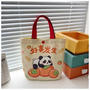 Close-up of canvas tote bag with panda print, red handles and snap button closure