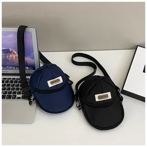 Detail of creative baseball cap shaped nylon mini crossbody bags in navy and black colors